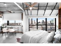 Bright bedroom boasts a modern ceiling fan, white bedding and a large window with fantastic city views at 100 Park W Ave # 2008, Denver, CO 80205
