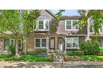 Charming townhouse featuring a brick facade, mature landscaping, and a welcoming entrance at 1209 S Flower Cir # C, Lakewood, CO 80232