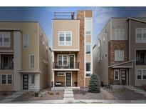 Modern three-story townhome featuring a rooftop deck and a blend of siding and stone accents at 8331 Farmers Way, Highlands Ranch, CO 80129