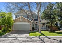 Charming two-story home featuring a stone facade, attached garage, and well-manicured lawn at 10519 Winterflower Way, Parker, CO 80134