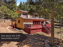 Charming two-story home with a spacious deck and a detached garage nestled among mature trees at 10852 Conifer Mountain Rd, Conifer, CO 80433