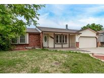 Charming single-story home with brick accents, manicured lawn, and attached garage at 1828 Stratford Ln, Longmont, CO 80503