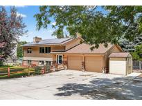 Inviting two-story home with a charming facade, large driveway, and solar panels on the roof at 8165 W Stene Dr, Littleton, CO 80128