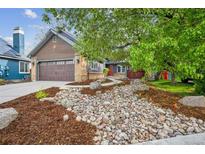 Charming home with a well-manicured front yard featuring rock landscaping and lush greenery at 10729 Kipling Way, Broomfield, CO 80021