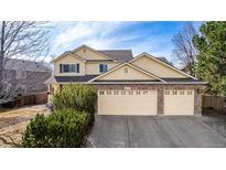 Charming two-story home featuring a three car garage and well-maintained landscaping on a sunny day at 10722 W 54Th Pl, Arvada, CO 80002