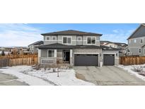 Two-story house with gray siding, three-car garage, and landscaping at 11633 Norfolk St, Commerce City, CO 80022