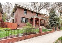 Charming red brick home with a welcoming front porch and well-maintained lawn at 925 N Emerson St, Denver, CO 80218
