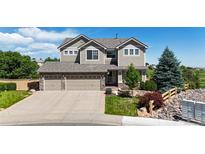 Charming two-story home with a well-manicured front yard and three-car garage at 10533 Redcone Way, Highlands Ranch, CO 80130