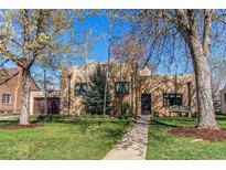 Charming brick home with a well-manicured lawn, garden and covered front porch at 2838 Forest St, Denver, CO 80207