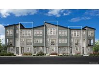 Modern townhome with stone accents, large windows, and a well-maintained lawn at 20618 E 63Rd Ave, Aurora, CO 80019