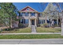 Charming two-story home with well-maintained lawn, brick facade, and black shutters for a classic curb appeal at 8641 Coors St, Arvada, CO 80005