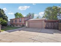 Charming two-story home featuring a spacious driveway, attached two-car garage, and well-maintained lawn at 11112 Dahlia Way, Thornton, CO 80233