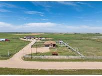 Sprawling ranch property featuring outbuildings and fenced pastures under a bright blue sky at 46303 E 106Th Ave, Bennett, CO 80102