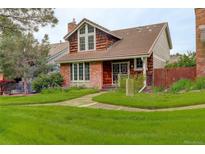Charming brick and shingle home featuring mature landscaping and a tile roof at 7409 E Jamison Dr, Centennial, CO 80112
