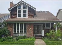 Charming two-story brick home with a well-manicured lawn and lush garden landscaping at 7409 E Jamison Dr, Centennial, CO 80112