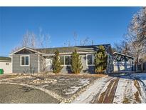 Newly renovated ranch home featuring a gray exterior, landscaped yard, and attached garage at 4770 S Jason St, Englewood, CO 80110