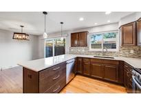 Modern kitchen with an island, hardwood floors, and updated cabinetry at 9026 E Mansfield Ave, Denver, CO 80237