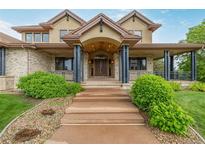 Inviting home entrance featuring a charming arched doorway and manicured landscaping at 14154 Lexington Cir, Westminster, CO 80023