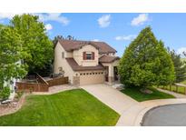 Beautiful home with a manicured lawn, attached two-car garage and mature landscaping at 9105 W Freiburg Pl, Littleton, CO 80127