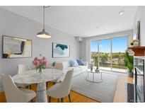 Bright living room featuring a dining area, comfortable seating, and a sliding door to a balcony with scenic views at 9019 E Panorama Cir # D418, Englewood, CO 80112