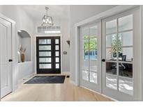 Bright entryway features modern door, stylish light fixture, and warm wood floors, creating an inviting ambiance at 828 Rabbit Run Dr, Golden, CO 80401