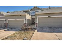 Townhouse exterior with two-car garage and landscaped front yard at 4460 S Jebel Ln, Centennial, CO 80015