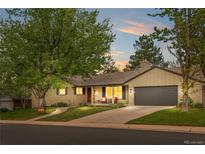 Charming single Gathering home boasts a manicured lawn, attached garage, and welcoming front porch at 3194 S Milwaukee St, Denver, CO 80210
