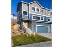 Two-story home with gray siding, yellow door and attached garage at 1728 Valley Oak Ct, Castle Rock, CO 80104