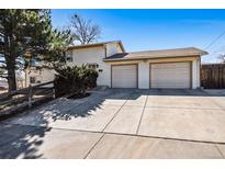 Charming home showcasing a spacious driveway and attached two-car garage, with a well-maintained yard and mature tree at 7815 Conifer Rd, Denver, CO 80221