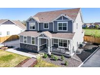 Charming two-story home featuring a cozy front porch and manicured landscaping at 437 Buckskin Rd, Berthoud, CO 80513