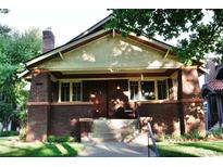 Charming brick home with Craftsman details, inviting front porch and well-maintained landscaping in a quiet neighborhood at 723 Steele St, Denver, CO 80206