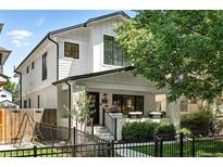Charming two-story home with a white brick facade, dark trim, well-manicured landscaping, and a cozy front porch at 474 S Vine St, Denver, CO 80209