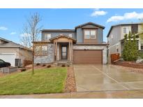 Charming two-story home with a stone facade and a well-maintained lawn at 1820 Ghost Dance Cir, Castle Rock, CO 80108