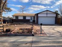 Charming single-Gathering home with a brick exterior, a manicured lawn, and an attached two-car garage at 16390 E Bates Dr, Aurora, CO 80013