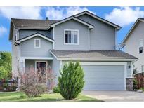 Charming two-story home featuring a two-car garage, manicured lawn and appealing curb appeal at 9595 Marmot Ridge Cir, Littleton, CO 80125
