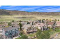 Stunning aerial view showcasing a neighborhood with mountain views and lush greenery in a desirable location at 11065 W Rockland Dr, Littleton, CO 80127