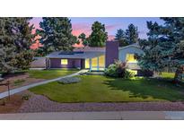 Charming single-Gathering home with a well-manicured lawn and beautiful landscaping at dusk at 1830 Zang St, Golden, CO 80401