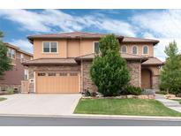 Stunning two-story home features a tile roof, stone accents, a well-manicured lawn, and a three-car garage at 10783 Skydance Dr, Highlands Ranch, CO 80126