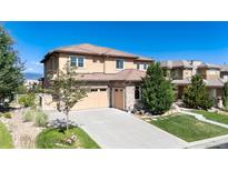 Elegant two-story home featuring a tile roof, stone accents, and an attached three-car garage at 10783 Skydance Dr, Highlands Ranch, CO 80126