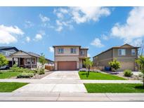 Charming two-story home with a well-manicured lawn and attached two-car garage at 502 Ledge St, Brighton, CO 80603