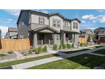 Charming townhome featuring a covered porch, low maintenance landscaping, and neutral exterior colors at 28330 E 6Th Pl, Watkins, CO 80137