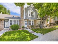 Charming two-story townhome featuring a well-maintained lawn, brick accents, and beautiful surrounding trees at 4130 E 94Th Ave # B, Thornton, CO 80229