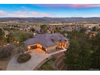 Stunning aerial view of a spacious home with a large driveway, surrounded by trees and overlooking a beautiful landscape at 4605 Tierra Alta Dr, Castle Rock, CO 80104