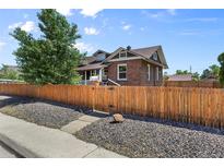 Charming brick home with a wooden fence and a well-manicured front yard at 5008 Sherman St, Denver, CO 80216