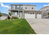 Beautiful two-story home with stone accents, lush lawn, and a three-car garage at 2248 Rosette Ln, Castle Rock, CO 80104