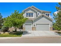 Beautiful two-story home with a three car garage, stone accents, and mature landscaping at 10441 Carriage Club Dr, Lone Tree, CO 80124