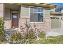 Charming exterior displaying brick accents, neutral siding, and manicured landscaping at 4406 Sidewinder Loop, Castle Rock, CO 80108