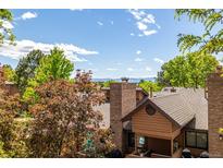 Scenic view of the property highlighting the lush landscaping and beautiful Colorado mountains beyond the rooftops at 9400 E Iliff Ave # 88, Denver, CO 80231