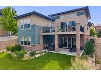 Spacious backyard featuring a patio, balcony, well-kept lawn, and inviting outdoor seating areas at 817 Backcountry Ln, Highlands Ranch, CO 80126