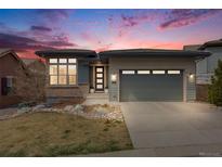 Beautiful single-Gathering home with a landscaped yard and a two-car garage. Twilight sky in the background at 817 Backcountry Ln, Highlands Ranch, CO 80126